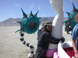 Burning Man Participant hugging fang of the Mouth bed